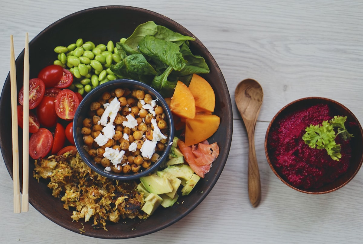 Bol coloré vu de dessus avec avocat, pois chiches, tomates et légumes